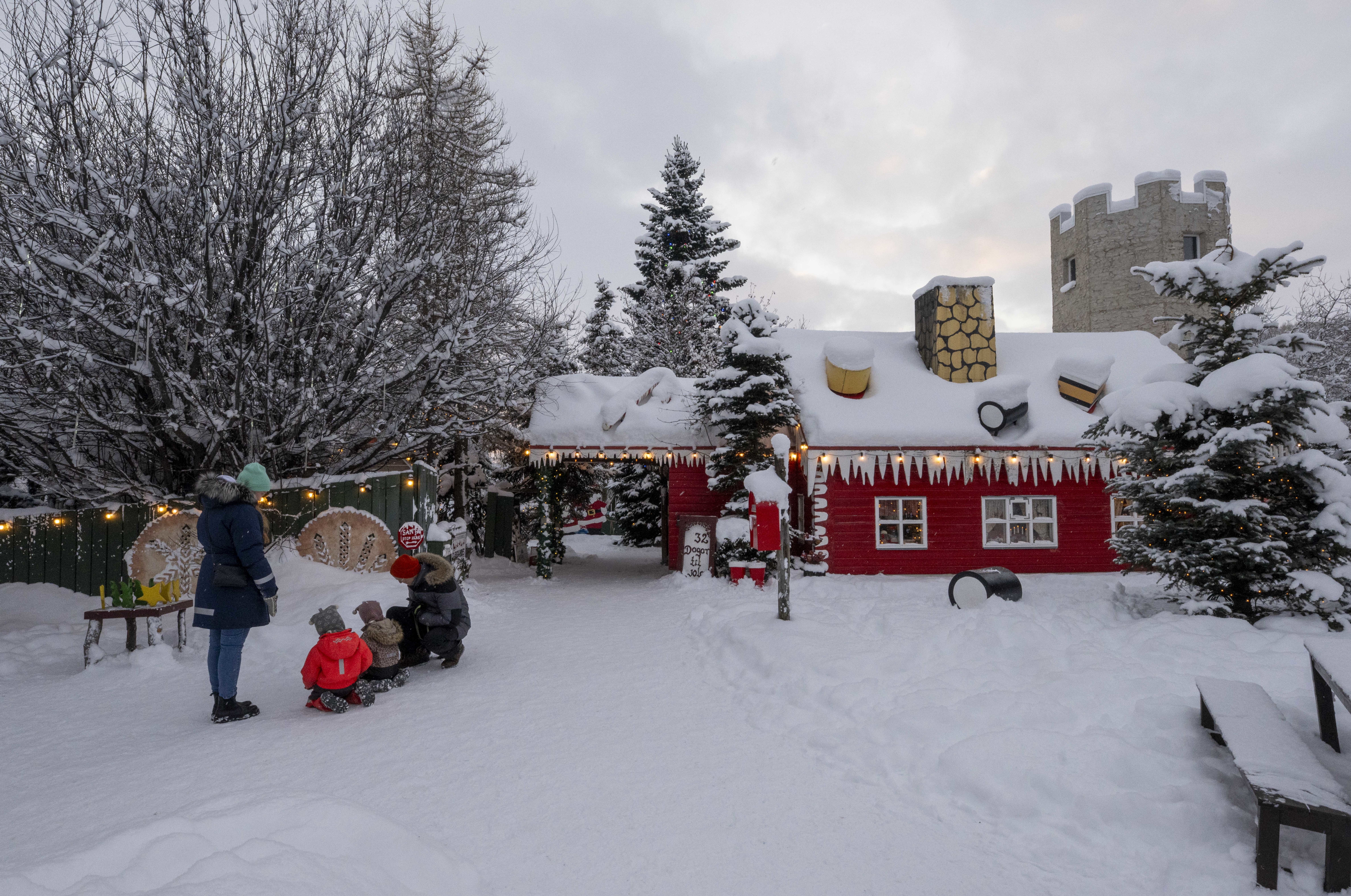 People interact at one of the entrances to a Christmas village in Akureyri, Iceland, on November 30, 2024. Christmas in Iceland, known as Jol, is a time deeply rooted in local traditions and unique folklore. Celebrations include typical foods, lighting candles, and decorating houses with lights to counteract the winter darkness, creating a cozy atmosphere in the middle of winter. (Photo by Jorge Mantilla/NurPhoto via Getty Images)