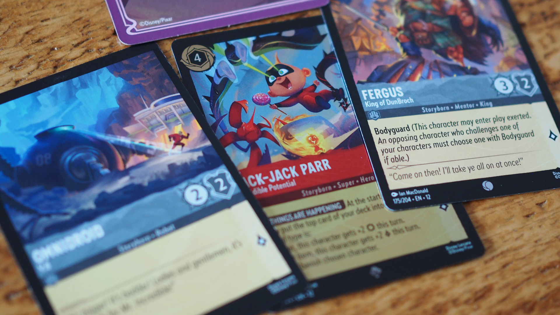 Jack-Jack, Fergus, and Omnidroid cards on wooden surface