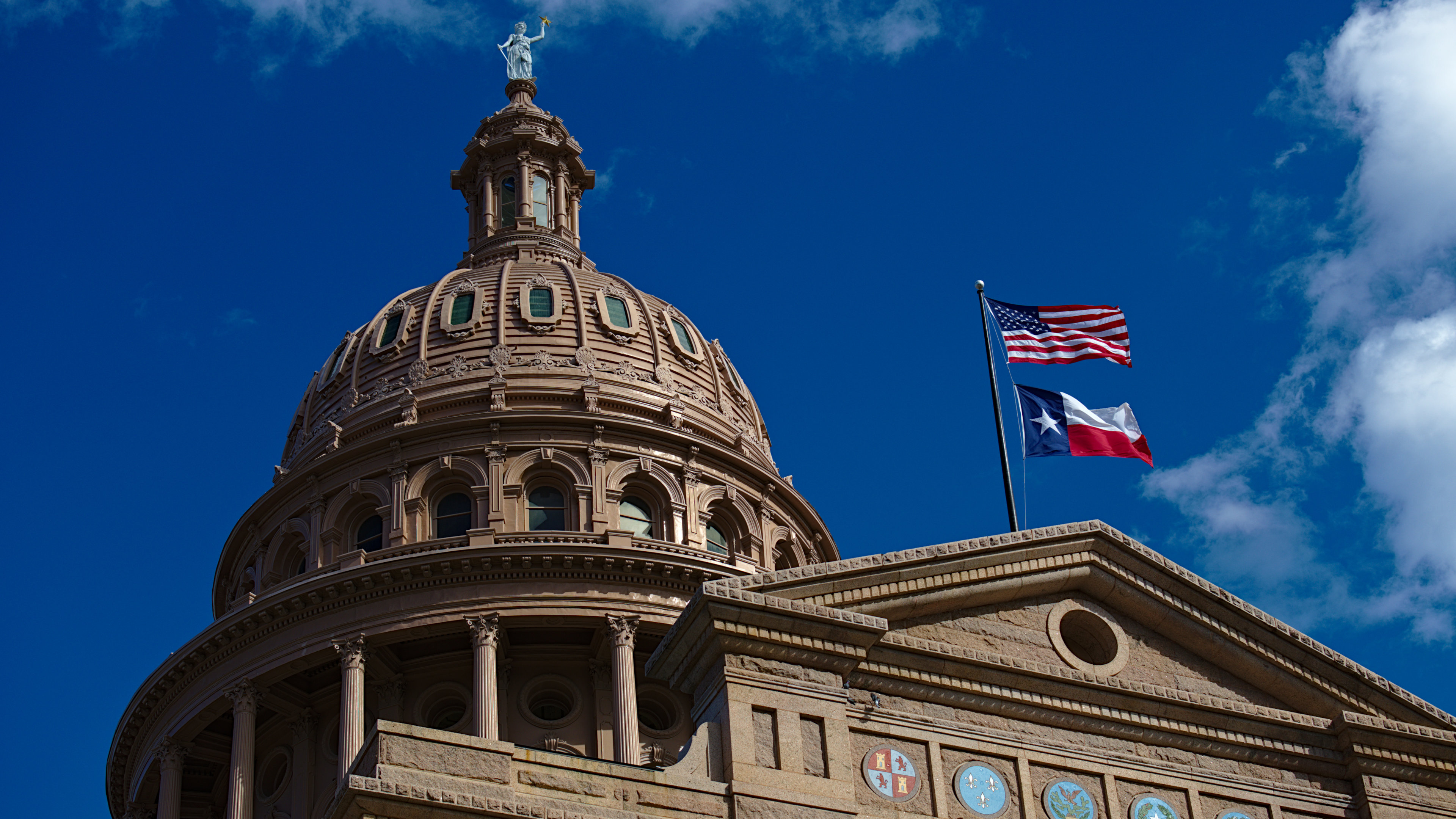 A photo of the pink marble granite Texas Capitol building, located at the end of Congress Avenue in downtown Austin, Texas.