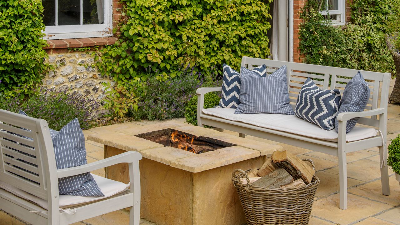 Firepit on patio made from stone slabs by two benches