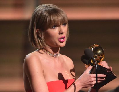 Taylor Swift accepts her Grammy award. 