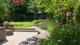 sloping garden ideas: paved path on sloping lawn