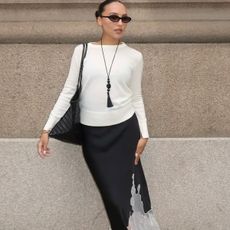 woman in white sweater and black silk skirt