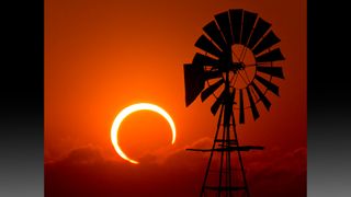 Annular eclipse with windmill at sunset.