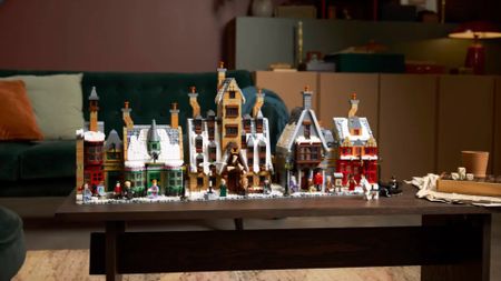 The Lego Hogsmeade Village - Collectors' Edition set laid out in a line on a wooden table