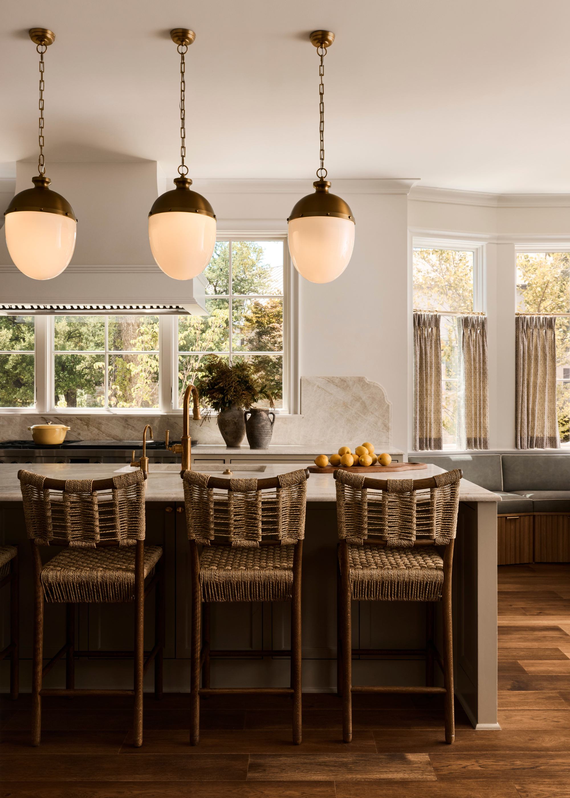 open plan kitchen with pendant lights over the island and a wall of windows