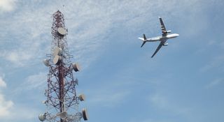 airplane flying over cellular tower