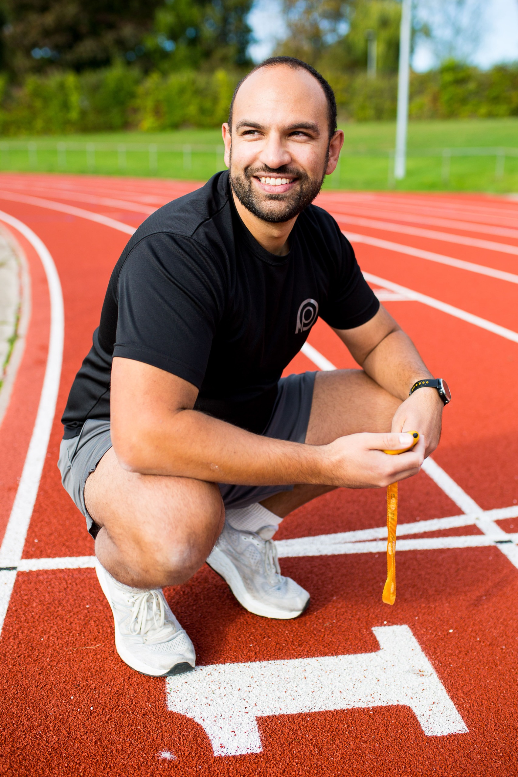 Arj smiling on running track crouching