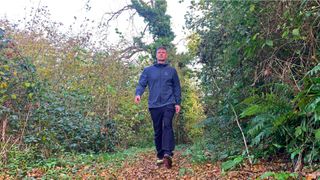 Man wearing Arc'teryx Gamma Lightweight Hoody walking through trees