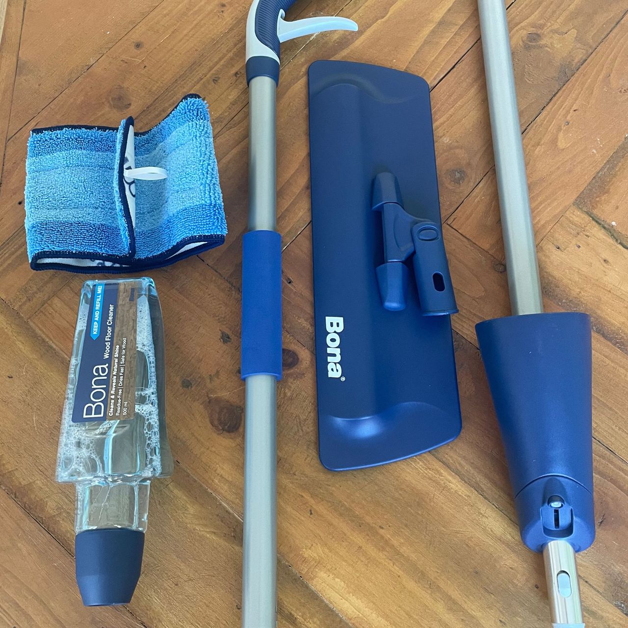 Components of the Bona Spray Mop Air laid out on a wooden table