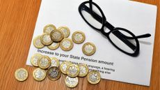 One pound coins on a letter about a state pension increase