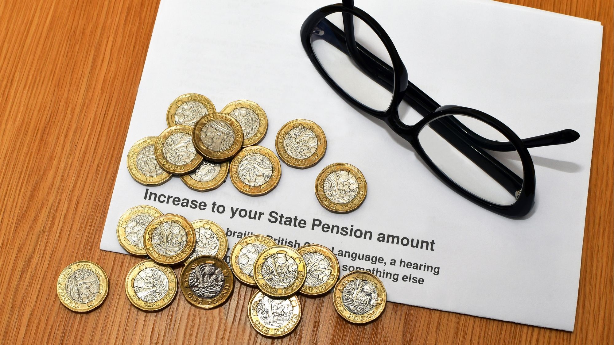 One pound coins on a letter about a state pension increase