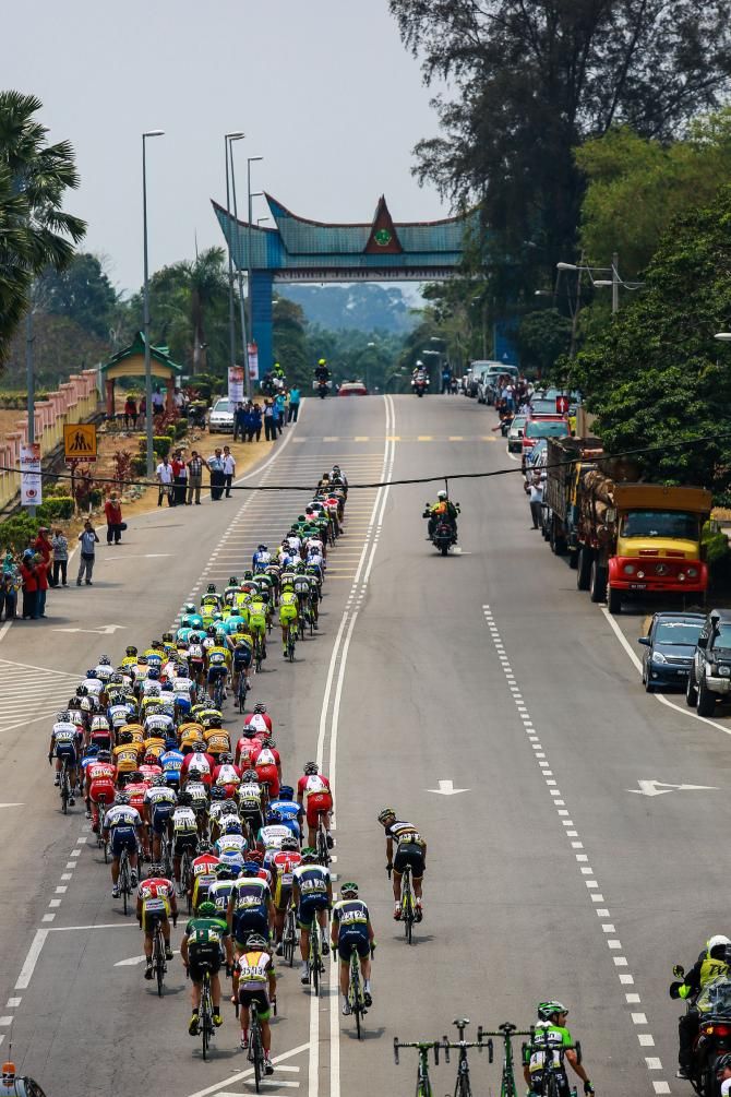 The fast moving peloton heads to an arch