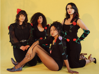 The four La Luz band members wearing black, with rose accessories