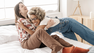 A happy couple cuddling on a bed