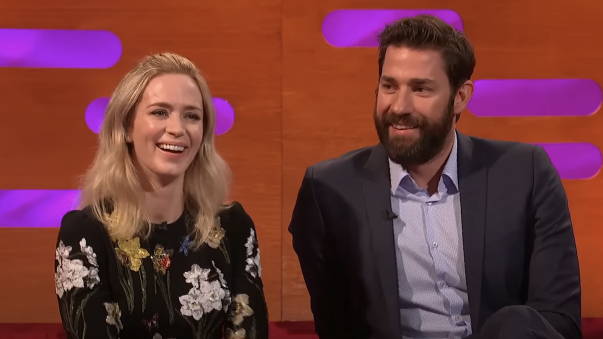 Emily Blunt and John Krasinski sit smiling next to each other on The Graham Norton Show. 