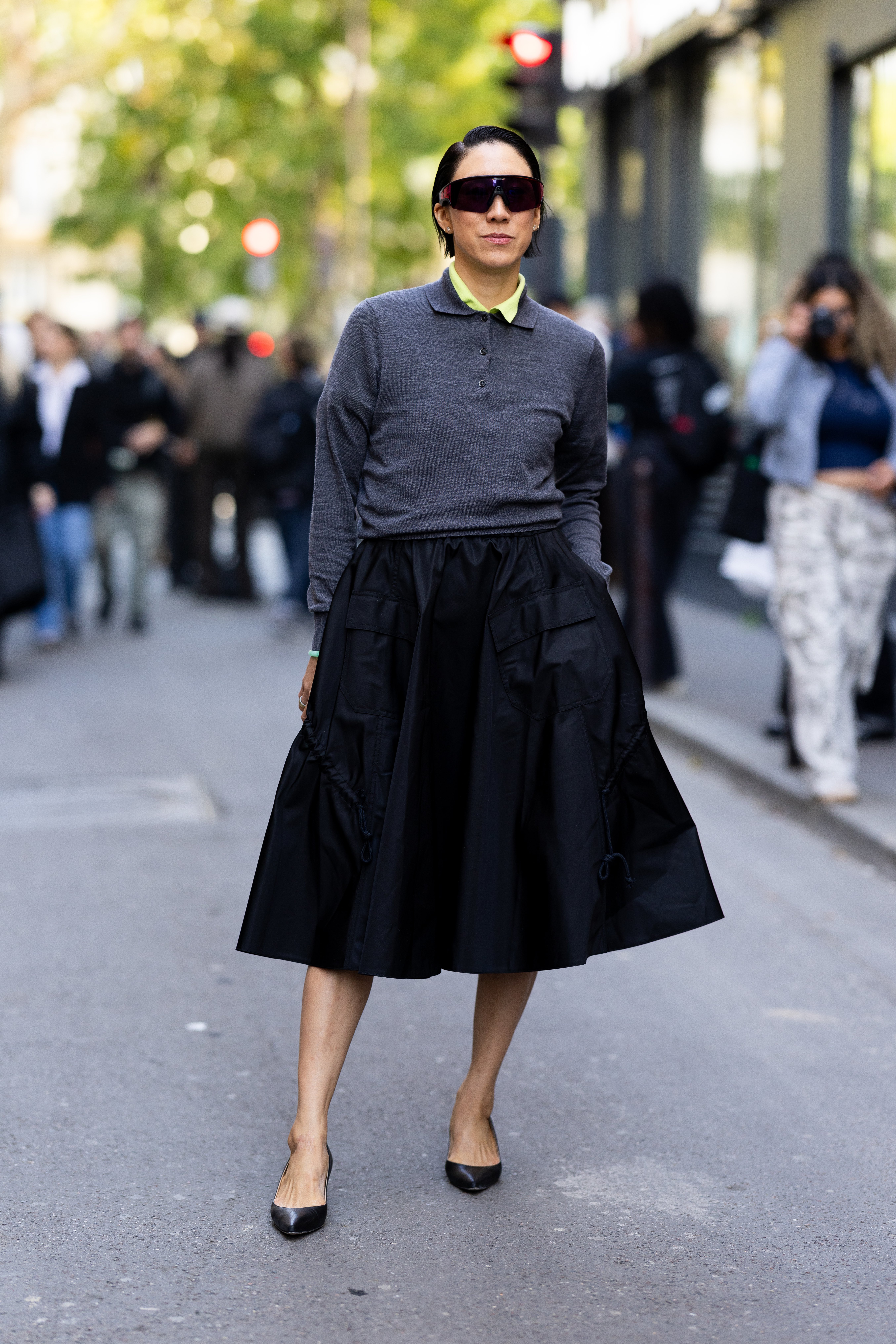 PARIS, FRANCE - OCTOBER 02: Eva Chen wears black sunglasses, black leather pumps, a black round skirt, a grey polo sweater and a green sweater outside Mugler show during the Womenswear Spring Summer 2026 as part of Paris Fashion Week on October 02, 2025 in Paris, France. (Photo by Valentina Frugiuele/Getty Images)