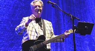 Glenn Tilbrook performs in a light checked suit with a black Telecaster
