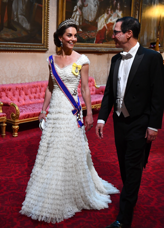 Britain's Catherine, Duchess of Cambridge (L) walks with US Secretary of Treasury Steven Mnuchin as they arrive through the East Gallery during a State Banquet in the ballroom at Buckingham Palace in central London on June 3, 2019, on the first day of the US president and First Lady's three-day State Visit to the UK. Britain rolled out the red carpet for US President Donald Trump on June 3 as he arrived in Britain for a state visit already overshadowed by his outspoken remarks on Brexi