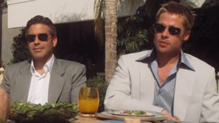 George Clooney and Brad Pitt sitting next to each other wearing sunglasses in Ocean&#039;s Eleven.