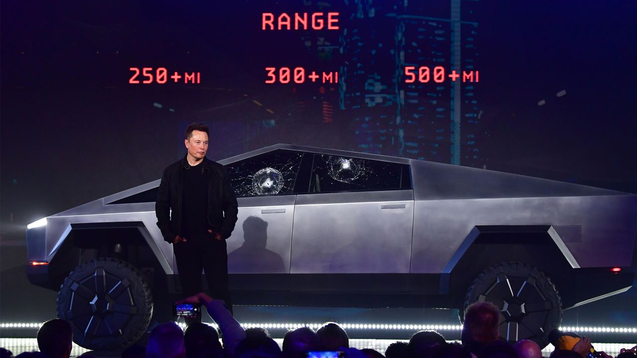 Elon Musk stands in front of Tesla&#039;s Cybertruck.