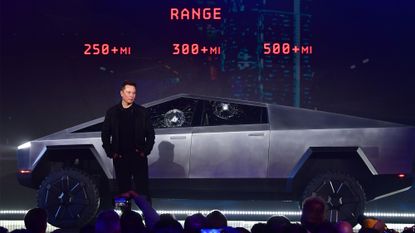 Elon Musk stands in front of Tesla's Cybertruck.