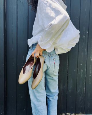 @neelam.ahooja wearing a white shirt, Levi's jeans, and The Row almond-toe court shoes.