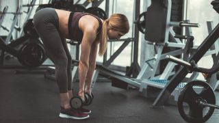 Woman performs stiff-legged deadlift leg exercise