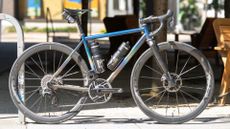 A custom bike (blue) is pictured side on in a street