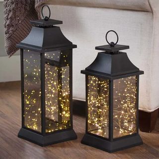 Two black lanterns with fairy lights inside
