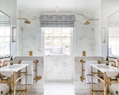 Cost to add a bathroom: White shared bathroom with white marble walls and brass details