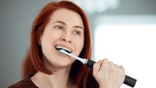 Woman uses one of the best electric toothbrushes