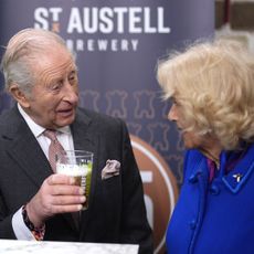 King Charles holding a beer talking to Queen Camilla 