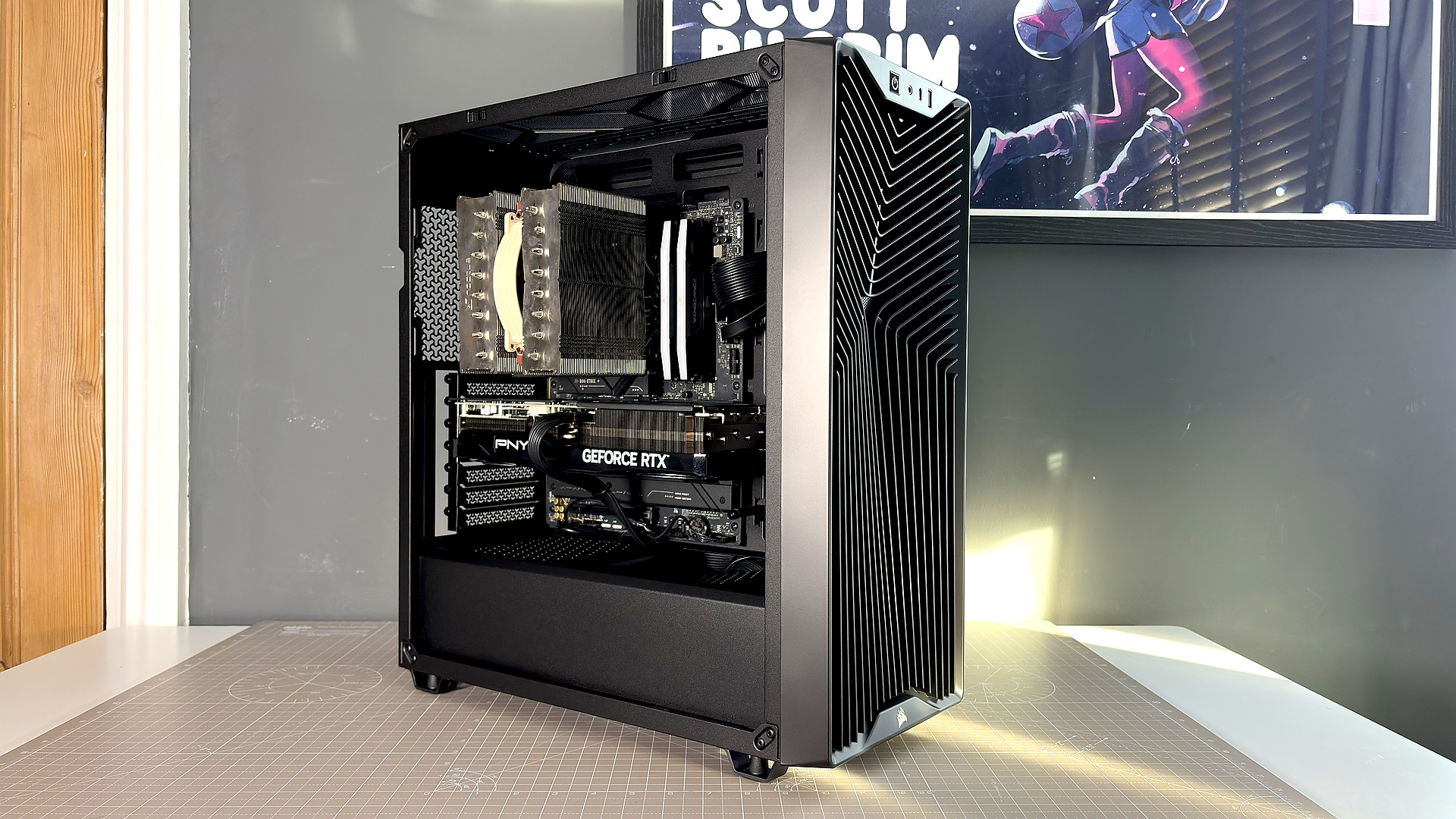 A Corsair PC case, the 3200D, on a desk with various panels removed and ready for a PC build.