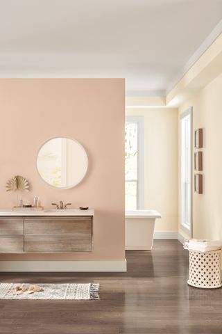 A living room with a pale pink paint on the walls