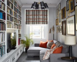 A snug in a living room with library bookshelves and grey corner sofa