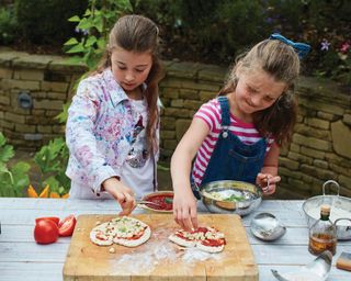 Children preparing pizza toppings for a pizza party