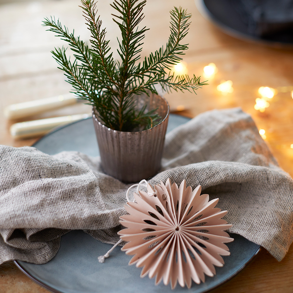 grey linen Christmas napkin draped neatly over blue plate