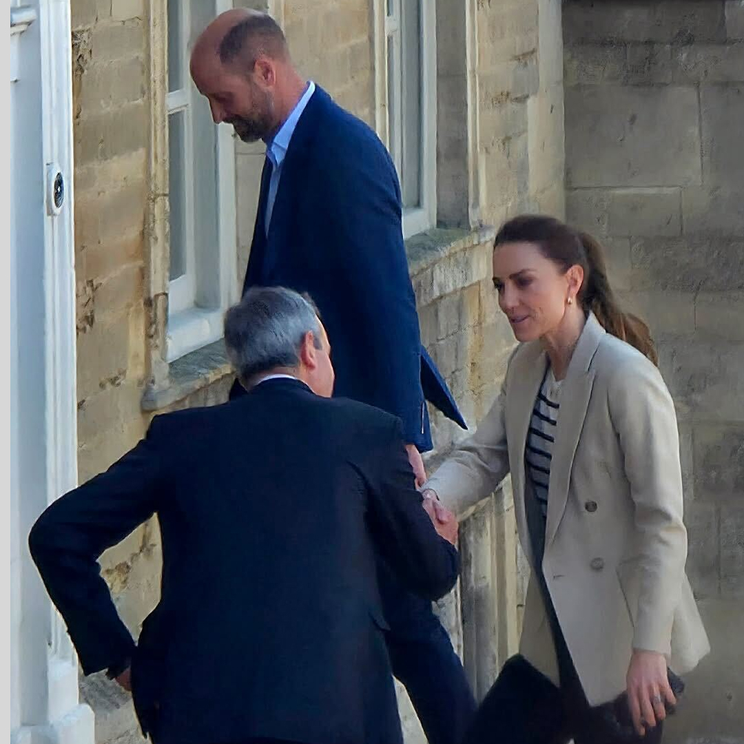 Princess Kate shaking hands with a man with Prince William walking behind her