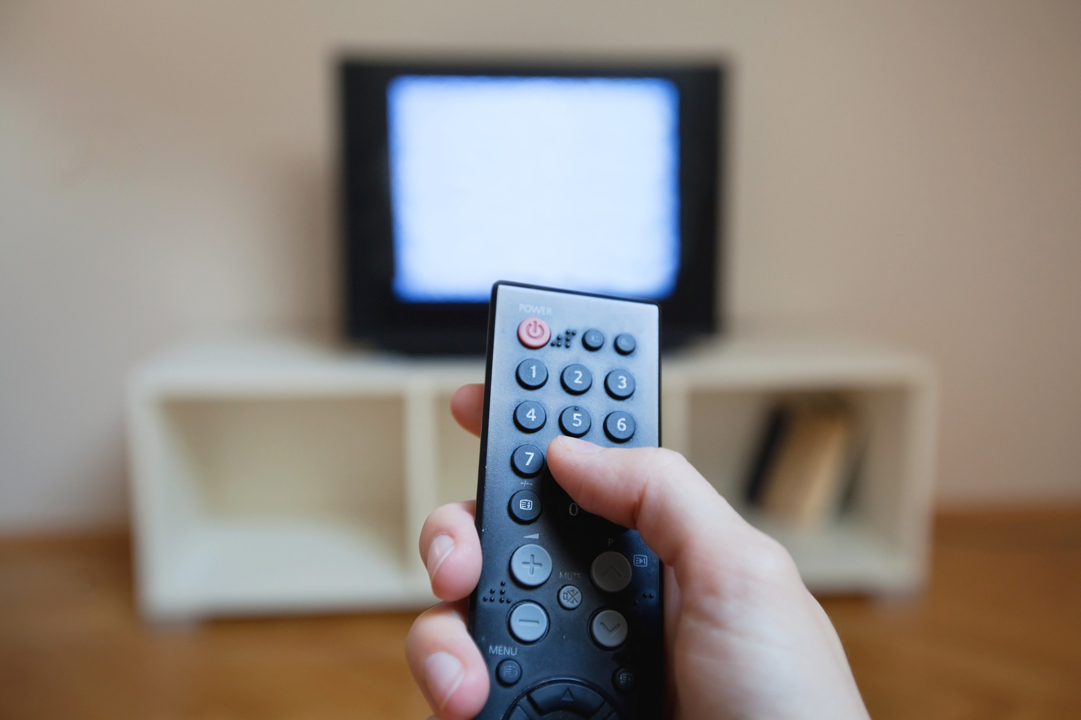 A person pointing a tv remote at a tv