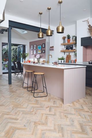 pink paneled kitchen island with white worktop