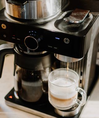 Ninja Espresso & Coffee Barista System making lungo espresso in fluted glass mug