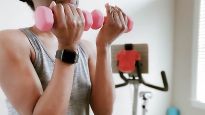 Woman doing bicep curls with a pair of light dumbbells