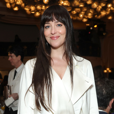 Dakota Johnson wearing a cream satin trench coat