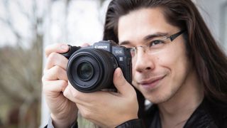 Man holding a Canon EOS RP up to his face