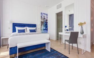 White guestroom with royal blue accents