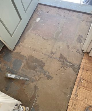 a dirty floor after the tiles covering it have just been removed