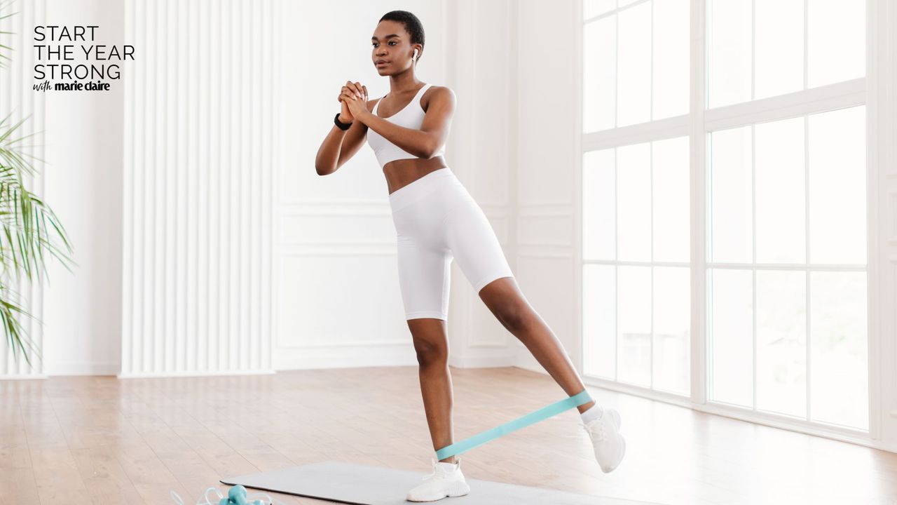 A woman doing advanced resistance band leg workouts at home on a yoga mat