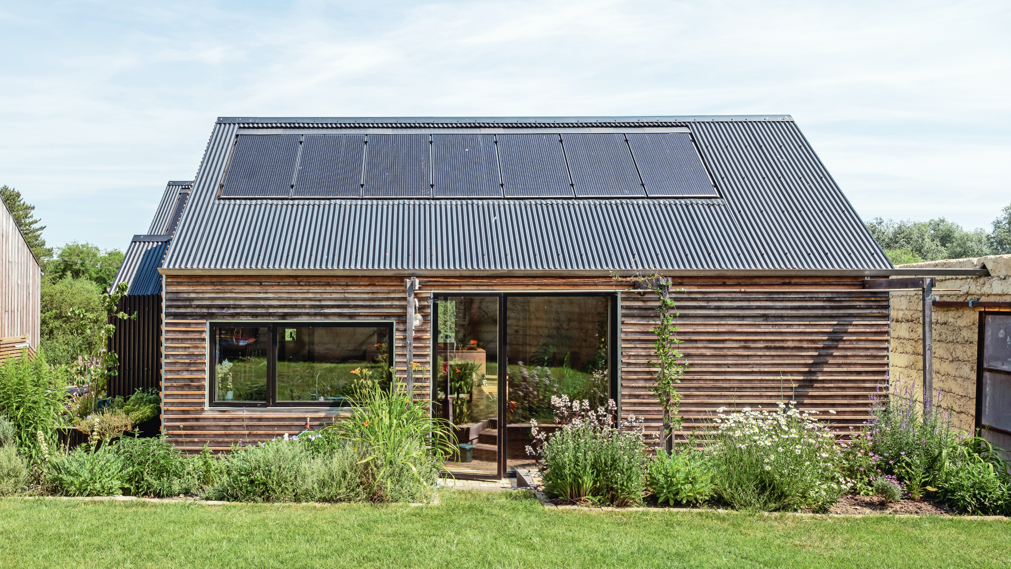 single storey timber clad home with solar panels on roof