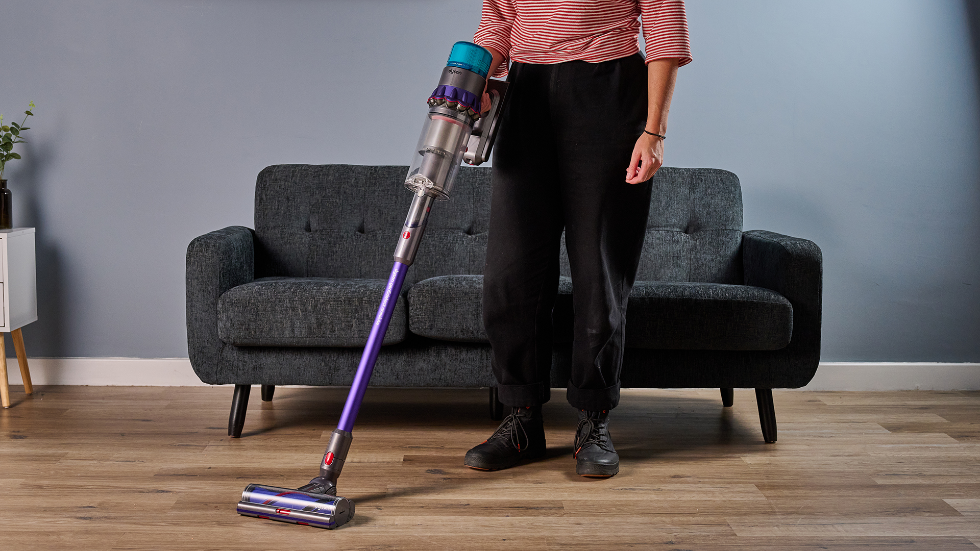 Ruth Hamilton holding the Dyson Gen5detect cordless stick vacuum, with a sofa and side table in the background